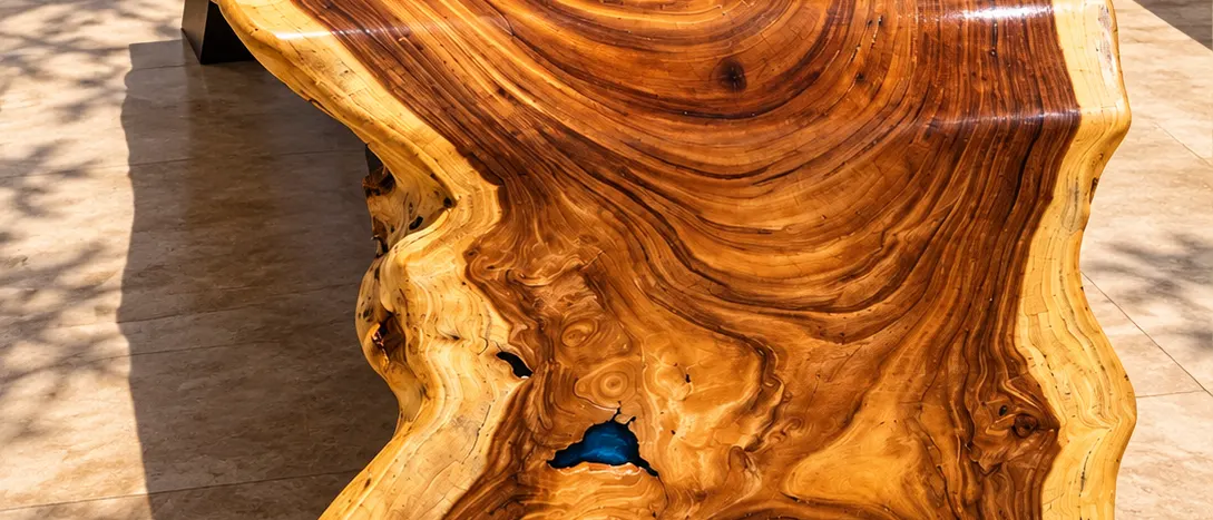 Mesa-rio de madeira com resina azul vista de cima, em área externa (imagem ilustrativa)