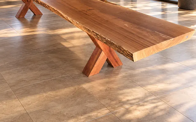 Mesa longa de prancha natural com pés em X de madeira maciça em sala ampla (imagem ilustrativa)